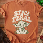 Orange t-shirt with "STAY FERAL" text and a cute goblin character.