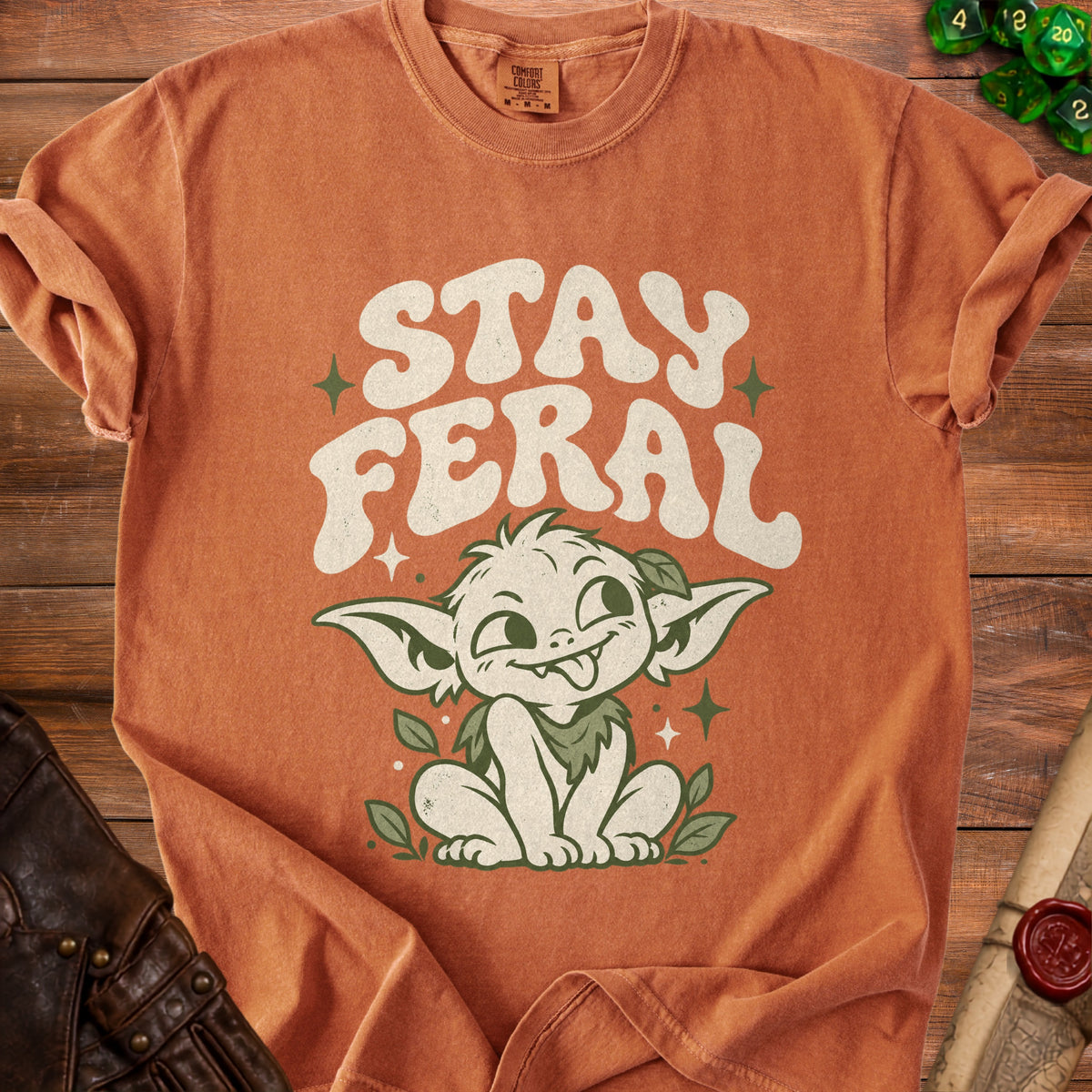 Orange t-shirt with "STAY FERAL" text and a cute goblin character.
