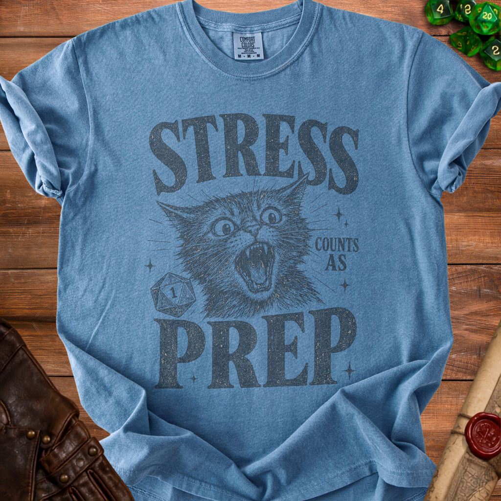 Blue t-shirt with distressed print of a cat saying "Stress Counts As Prep" and a D20 die.