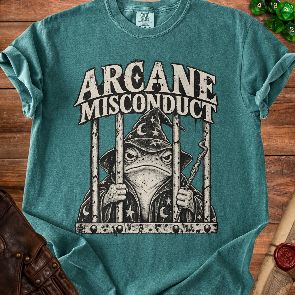Teal t-shirt with wizard frog design and text "ARCANE MISCONDUCT" on bars.
