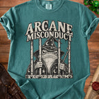 Teal t-shirt with wizard frog design and text "ARCANE MISCONDUCT" on bars.