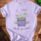 Lilac t-shirt with a cauldron overflowing with money, saying "I cast broke be gone!!"