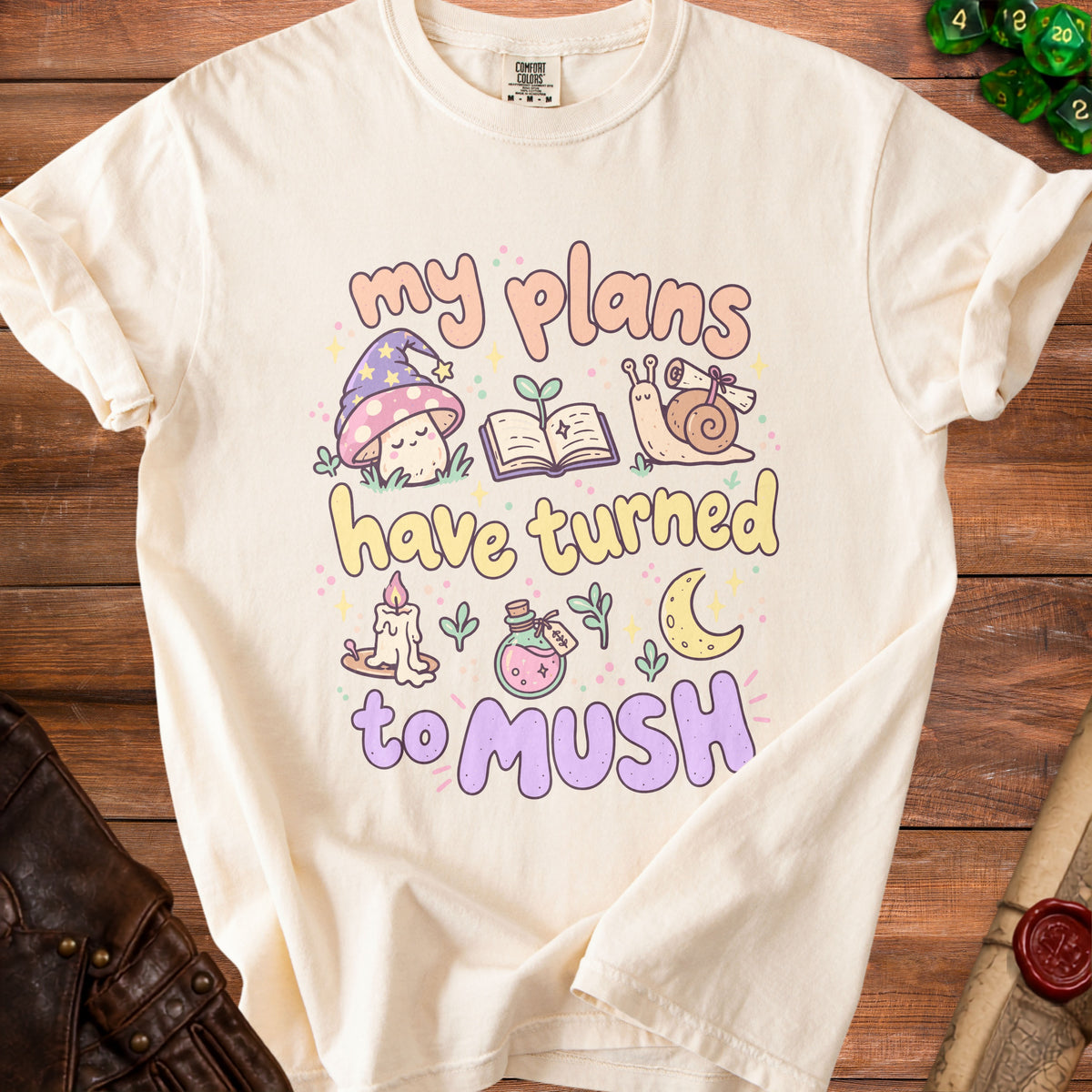 Cream t-shirt with "My plans have turned to mush" text and whimsical illustrations.