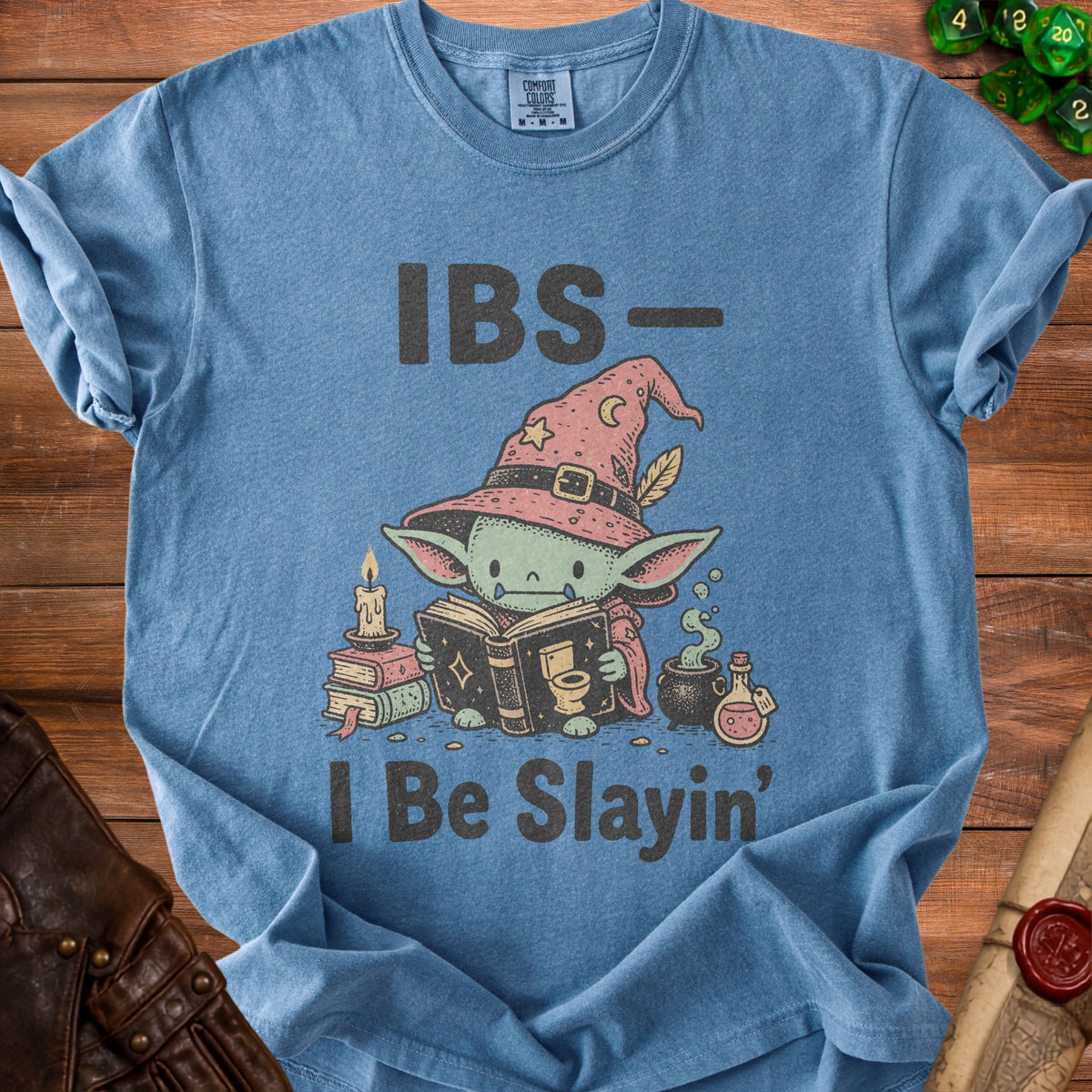 Blue t-shirt with text "IBS- I Be Slayin'" and a green creature in a witch hat.