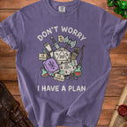 Purple t-shirt with dice, weapons, potion, and text "Don't worry I have a plan".