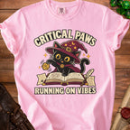 Pink t-shirt with black cat wizard graphic, "Critical Paws" and "Running on Vibes" text.