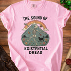 Pink t-shirt with skeleton, black cat, mountains, rainbow, and text "The Sound of Existential Dread".