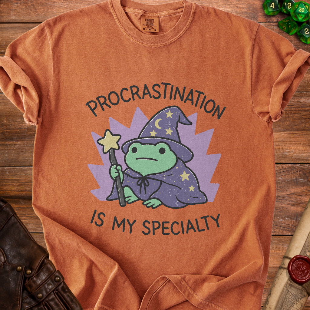 Orange t-shirt with wizard frog graphic and text "Procrastination Is My Specialty".