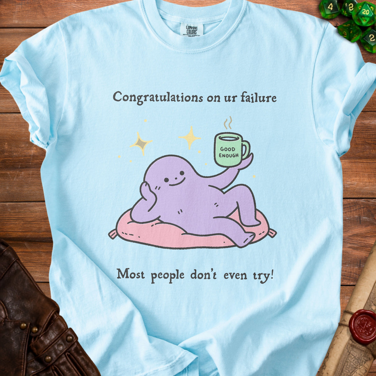 Light blue t-shirt with cartoon octopus holding mug that says "Good Enough."