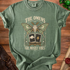 Green t-shirt with moth, moons, tarot cards, and text "The Omens Are Mostly Vibes".