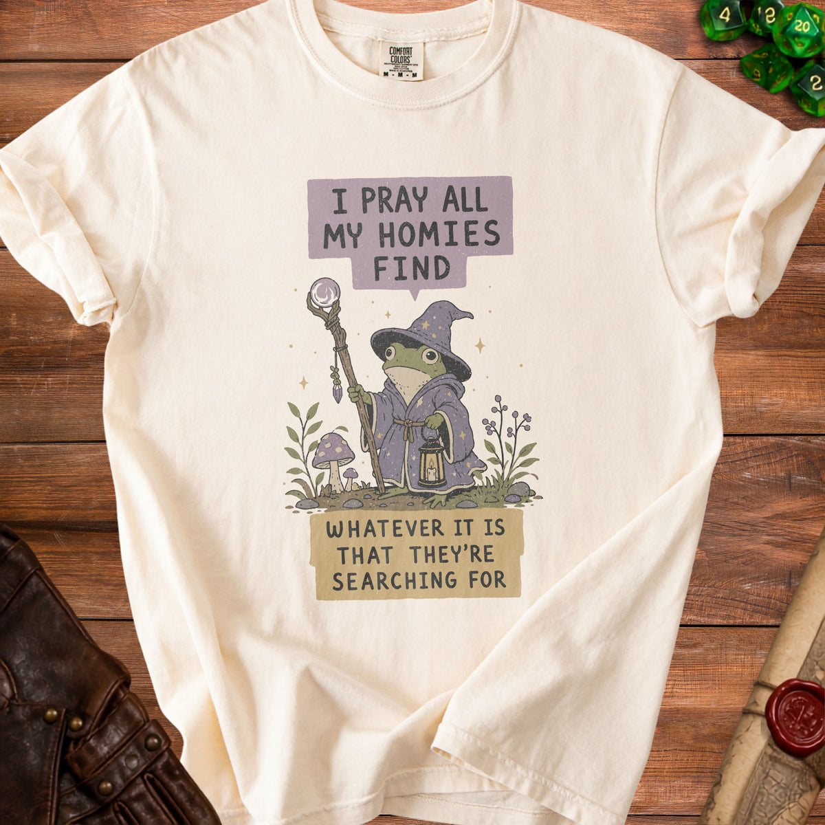 Cream t-shirt with wizard frog graphic and text "I pray all my homies find whatever it is that they're searching for".