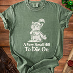 Green t-shirt with a cartoon cat knight design and text "A Very Small Hill To Die On".