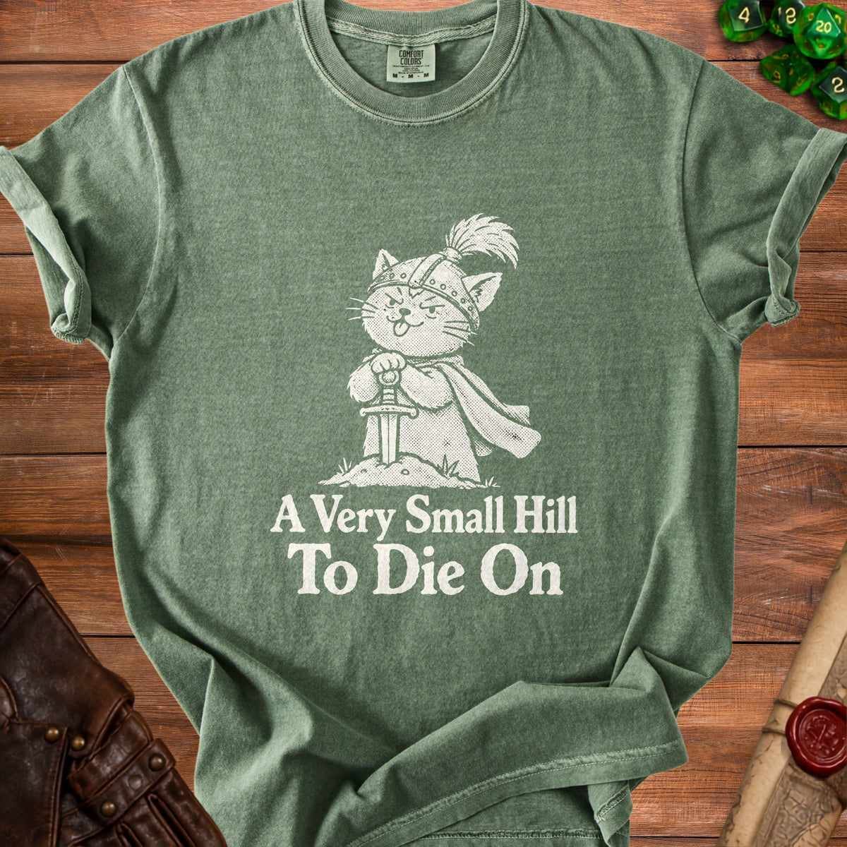 Green t-shirt with a cartoon cat knight design and text "A Very Small Hill To Die On".