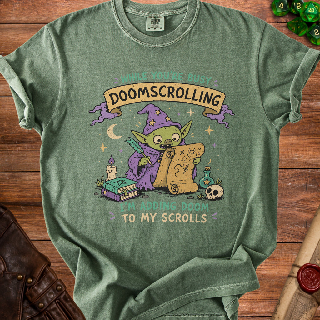 Green t-shirt graphic of a wizard goblin writing "I'm adding doom to my scrolls".