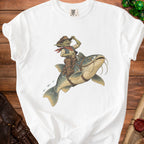 White t-shirt with graphic of a goblin cowboy riding a catfish.
