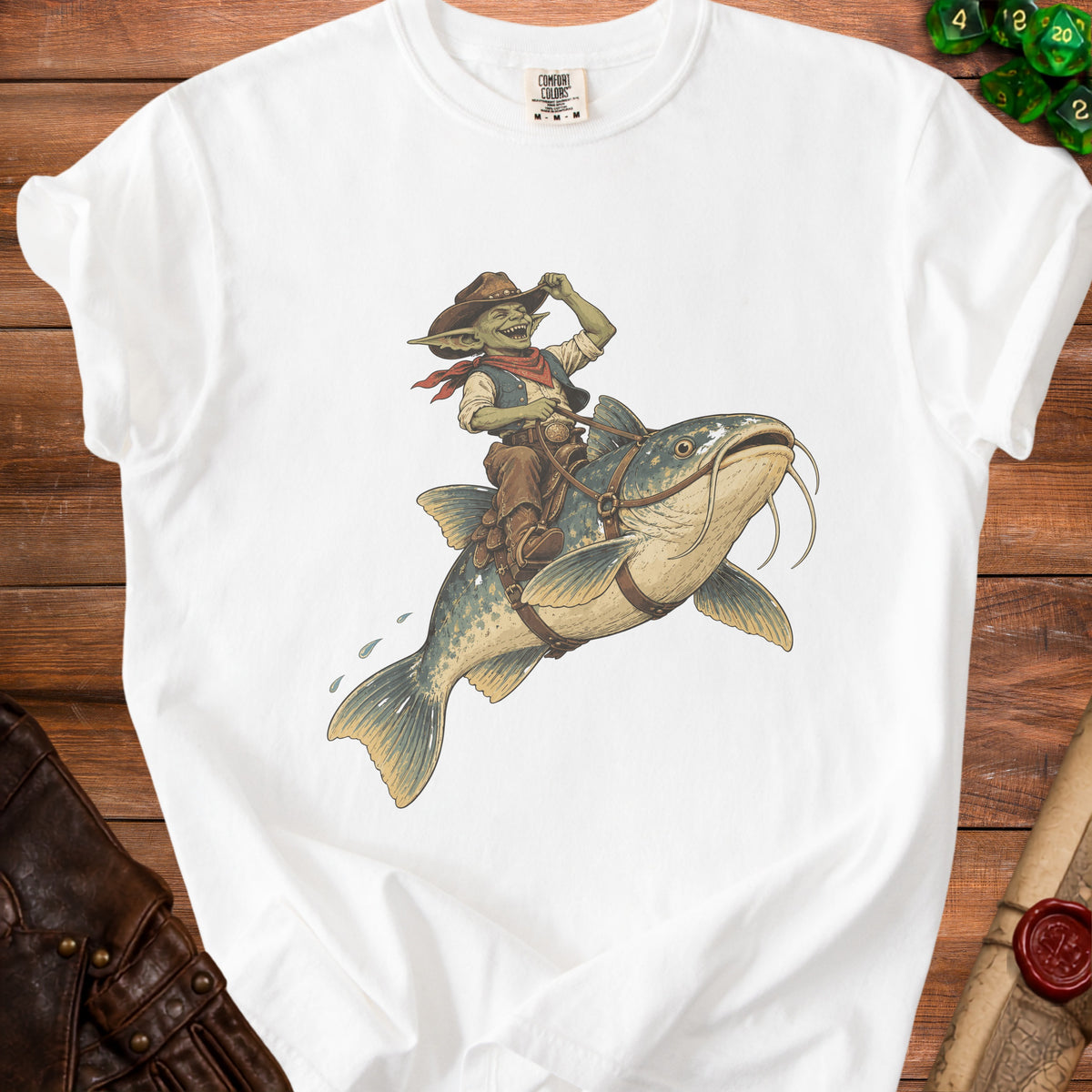 White t-shirt with graphic of a goblin cowboy riding a catfish.