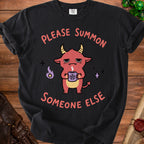 Black t-shirt with a red cartoon devil holding a pentagram mug and text.