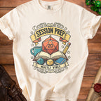 Cream t-shirt with "Session Prep Mostly Vibes" D20 dice, book, and pencil graphic.