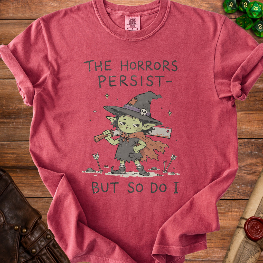 Red t-shirt with graphic of a goblin holding a cleaver, text reads "The Horrors Persist - But So Do I".