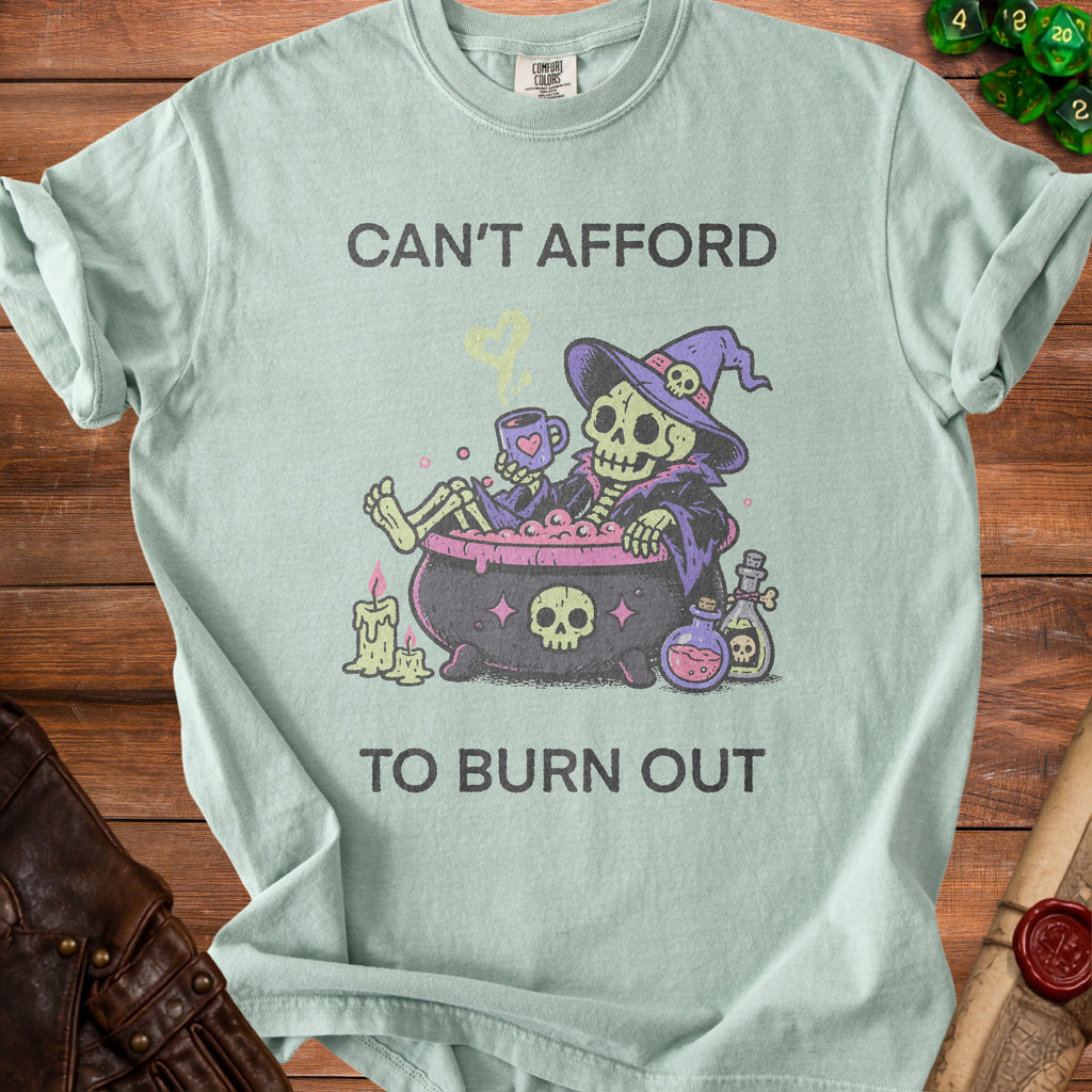 Mint t-shirt with skeleton in cauldron and text "CAN'T AFFORD TO BURN OUT".