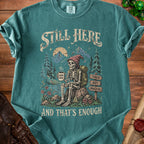 Skeleton hiker with coffee mug and backpack, text "Still Here And That's Enough".