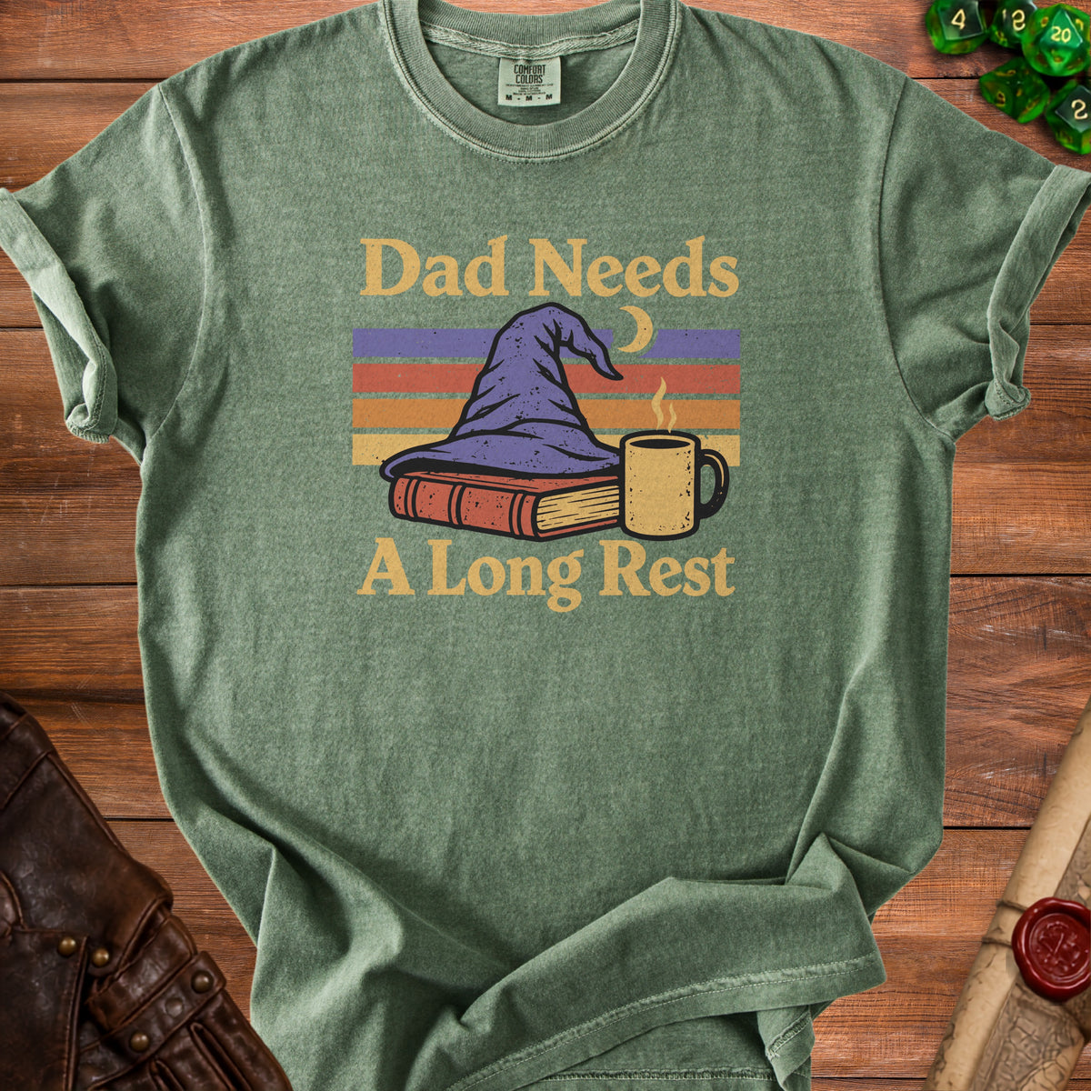 Green t-shirt with "Dad Needs A Long Rest" text, witch hat, book, and coffee mug graphic.