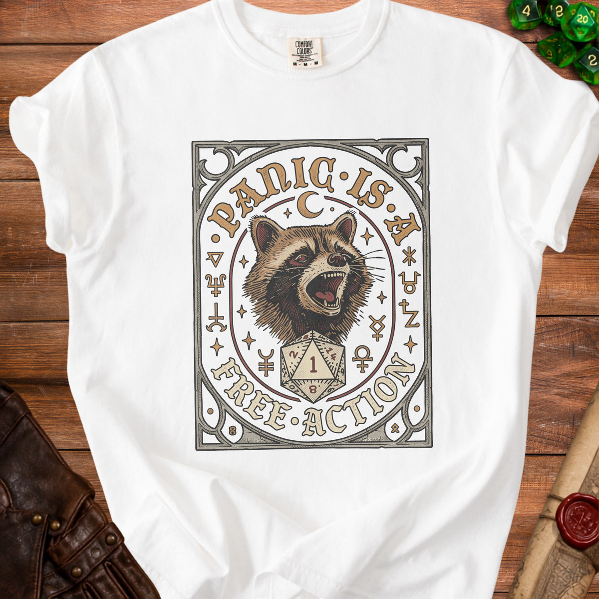 White t-shirt with a graphic of a raccoon, d20 die, and text "PANIC IS A FREE ACTION".