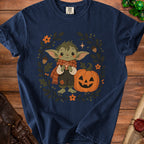 Navy t-shirt with a cute creature, pumpkin, and fall leaves graphic.