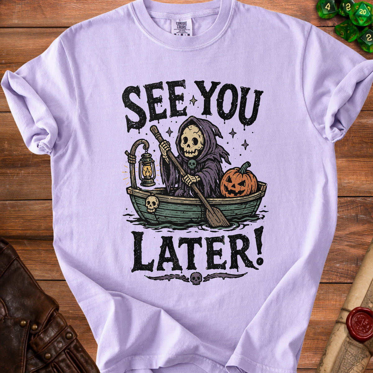 Grim reaper rowing boat with pumpkin, "See You Later!" text on purple t-shirt.