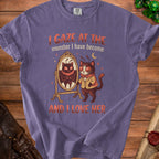 Purple t-shirt with a moth-like cat looking in a mirror, text reads "I GAZE AT THE monster I have become AND I LOVE HER".