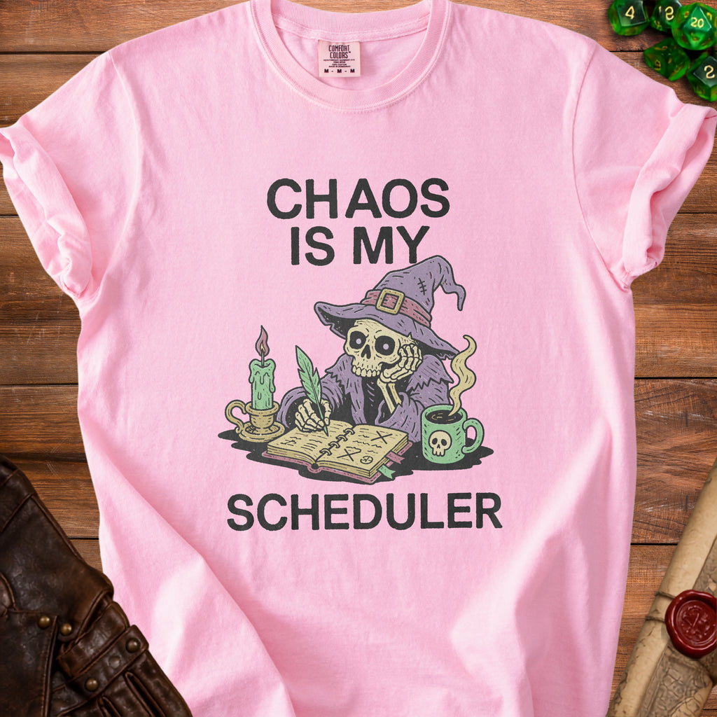 Pink t-shirt with skeleton witch, coffee, and text "Chaos Is My Scheduler".