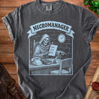 Dark grey t-shirt with a light blue graphic of a skeleton "NECROMANAGER" at a desk.