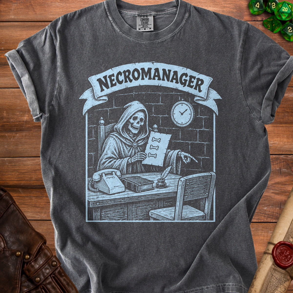 Dark grey t-shirt with a light blue graphic of a skeleton "NECROMANAGER" at a desk.
