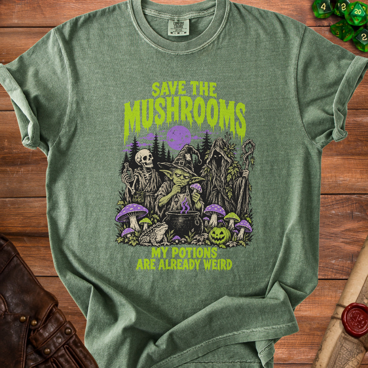 Green t-shirt with illustration of skeleton, goblin, and hooded figure saving mushrooms.