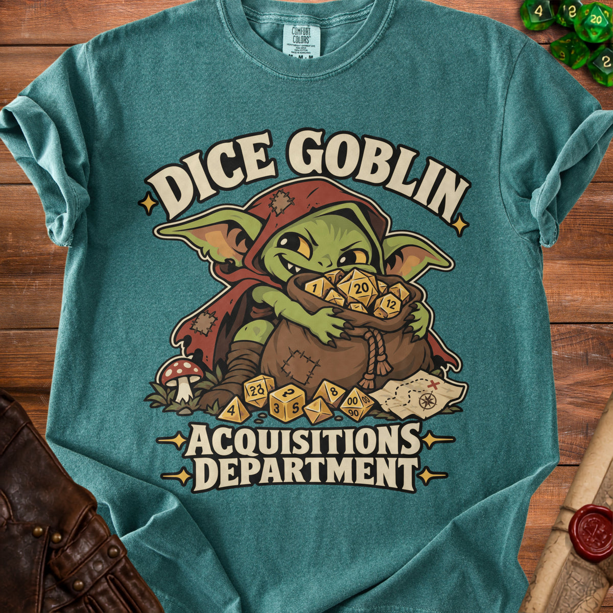 Teal t-shirt featuring a graphic of a green goblin clutching a large bag of dice.