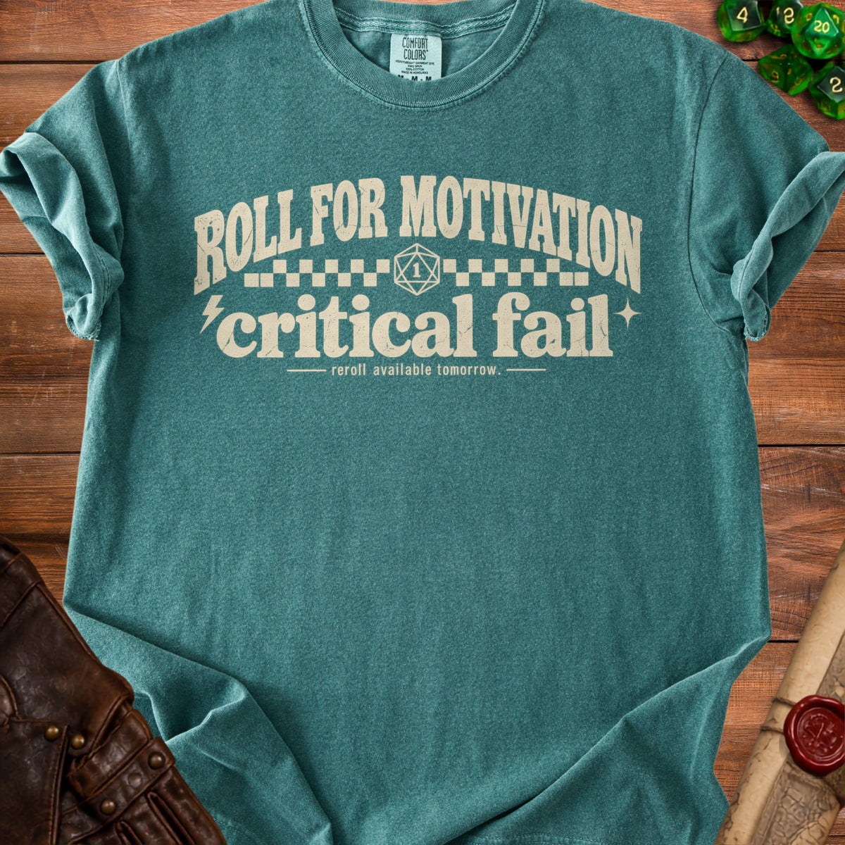 Teal t-shirt with "Roll for motivation, critical fail" text and dice.