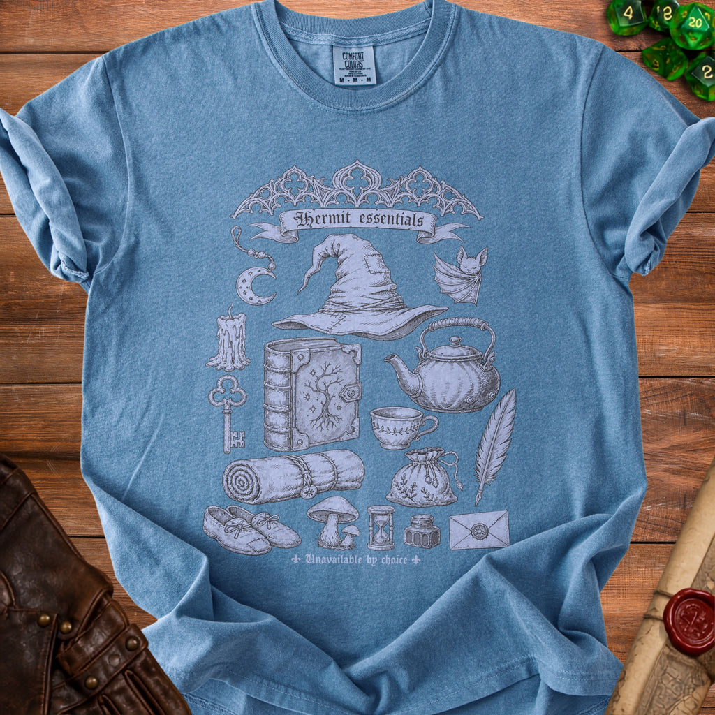 Blue t-shirt with "Hermit essentials" and various witchy items graphic.