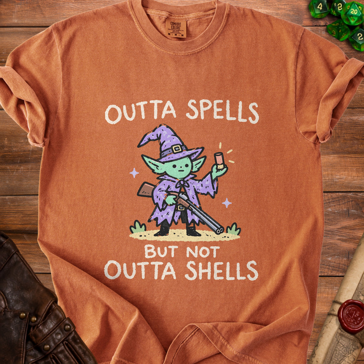 Orange t-shirt with cartoon character that says "Outta Spells But Not Outta Shells".