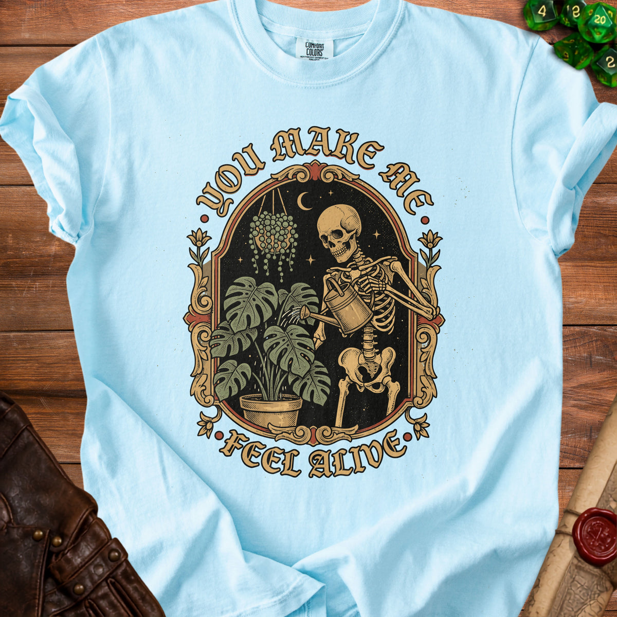 Skeleton watering plants with text "You Make Me Feel Alive."