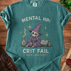 Green t-shirt with skeleton wizard graphic and "MENTAL HP: CRIT FAIL NEED LONG REST" text.