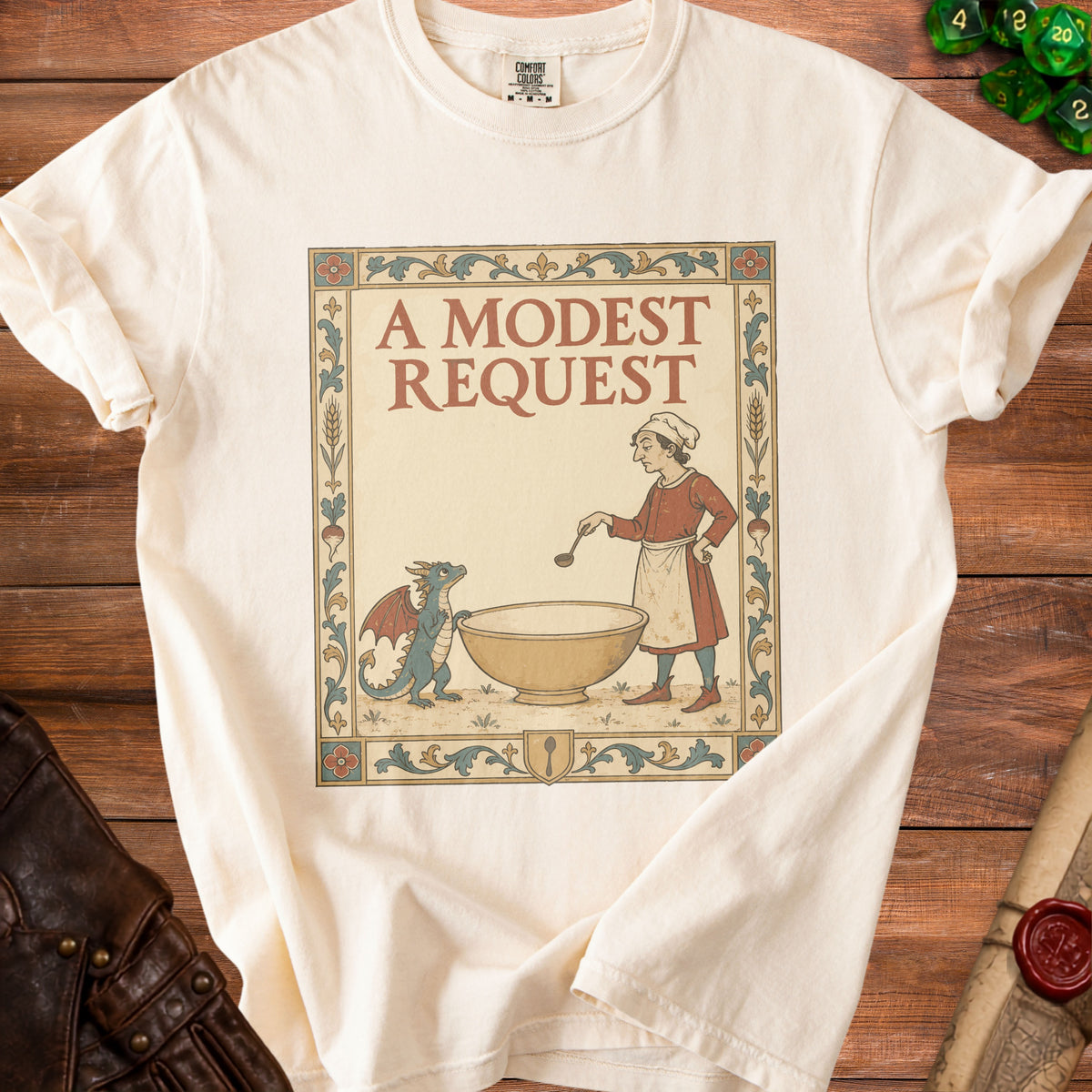 Cream t-shirt with a vintage illustration of a cook and a dragon, reading "A MODEST REQUEST".