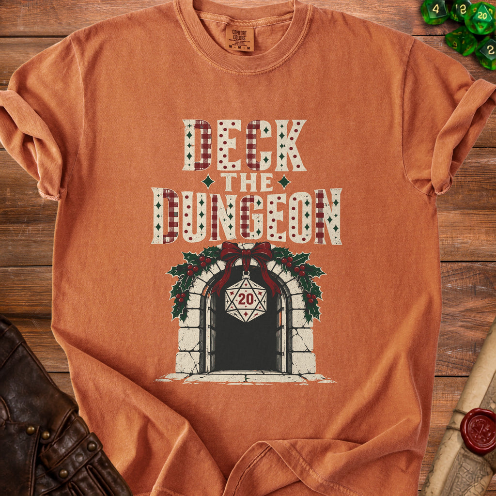 Orange t-shirt with "Deck the Dungeon" text and a festive doorway design.