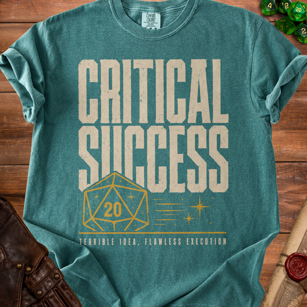 Teal t-shirt with "CRITICAL SUCCESS 20 TERRIBLE IDEA, FLAWLESS EXECUTION" text.