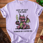 Lavender t-shirt with a pink dragon, sunglasses, and coffee cup graphic.