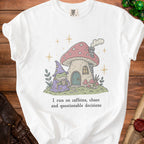 White t-shirt with frog wizard and mushroom house graphic and text.