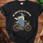 Wizard riding bicycle with black cat in basket, text "MY FAMILIAR CALLED SHOTGUN".