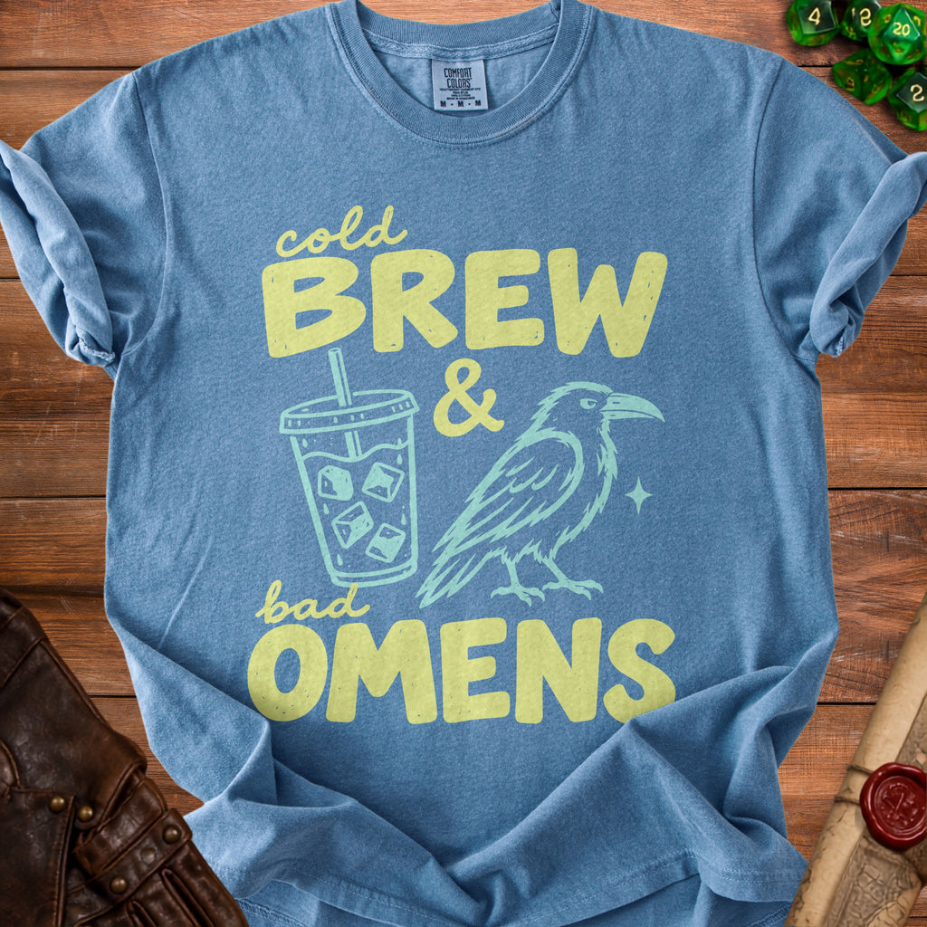 Blue t-shirt with yellow text "cold BREW & bad OMENS" and graphics.