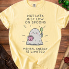 Yellow t-shirt with a ghost holding coffee and spoon, text "NOT LAZY, JUST LOW ON SPOONS MENTAL ENERGY IS LIMITED".