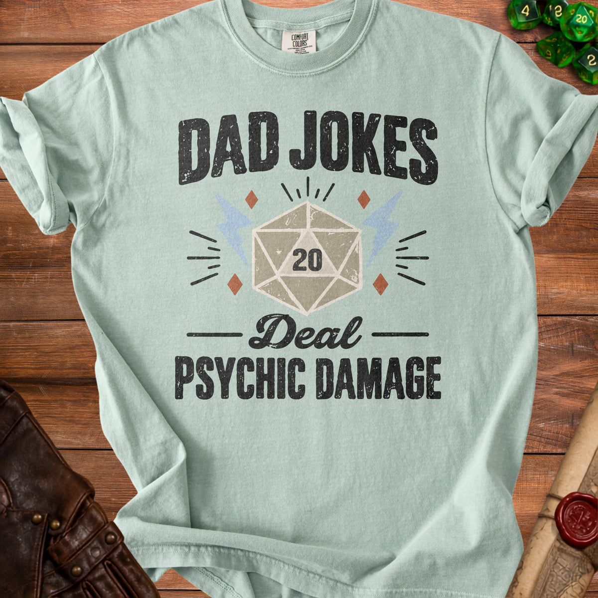 Light blue t-shirt with "DAD JOKES Deal PSYCHIC DAMAGE" and a D20 die.