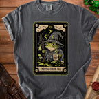 Grey t-shirt with tarot card graphic of a tired frog wizard and text "MENTAL CHECK: FAIL".